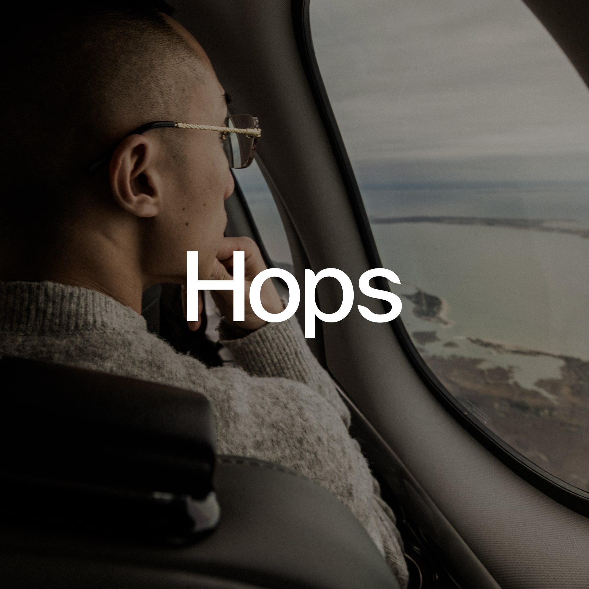 Person looking out the window of a private jet mid-flight.