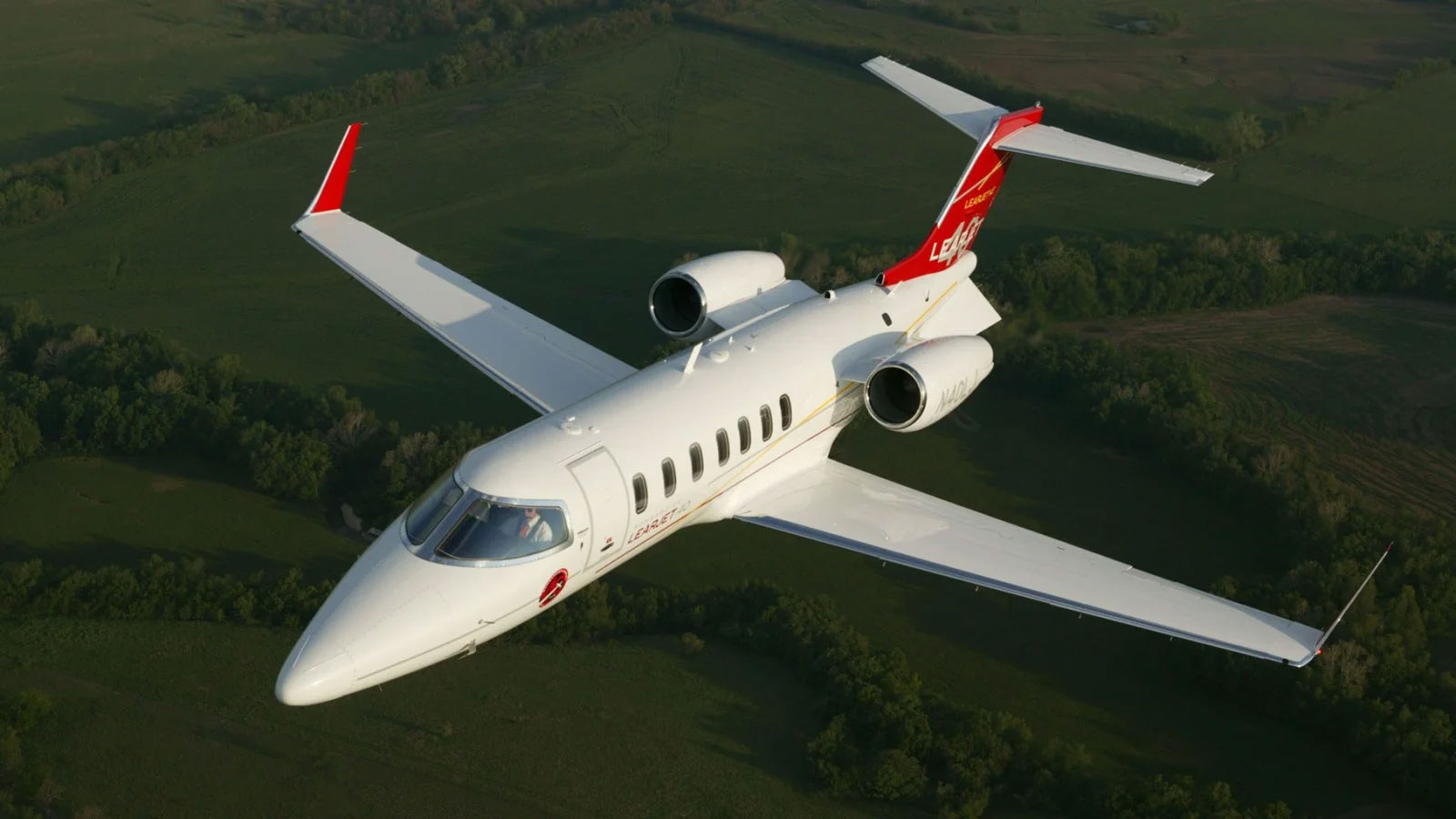 learjet 40 40xr flying over a green field