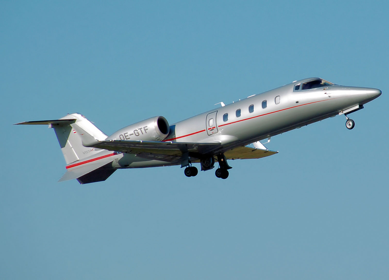Learjet 60 60xr grey flying into bluebird sky
